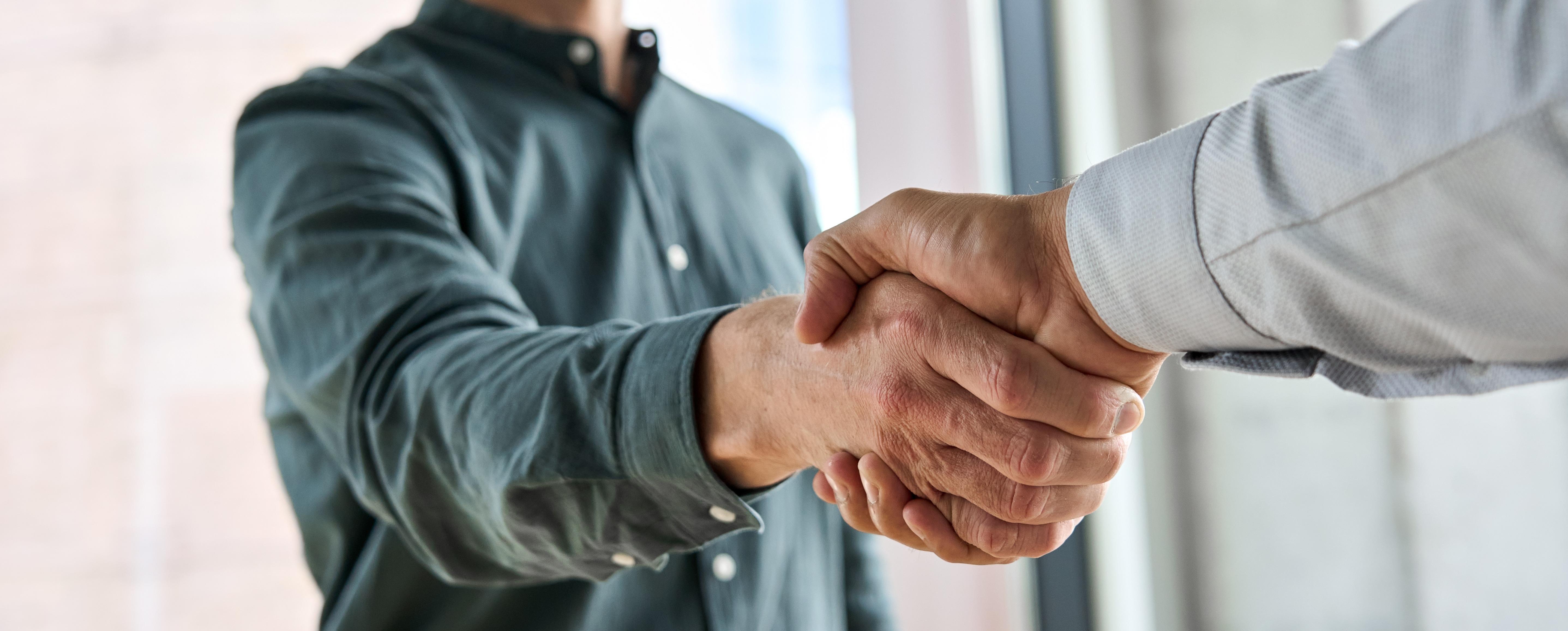 Primo piano di una stretta di mano tra partner, a simboleggiare un nuovo accordo di partnership.